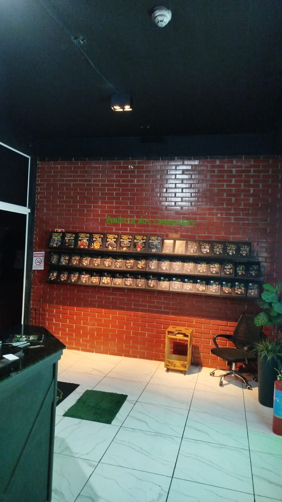 iluminação em trilho instalada no teto de estabelecimento comercial com parede de tijolinho